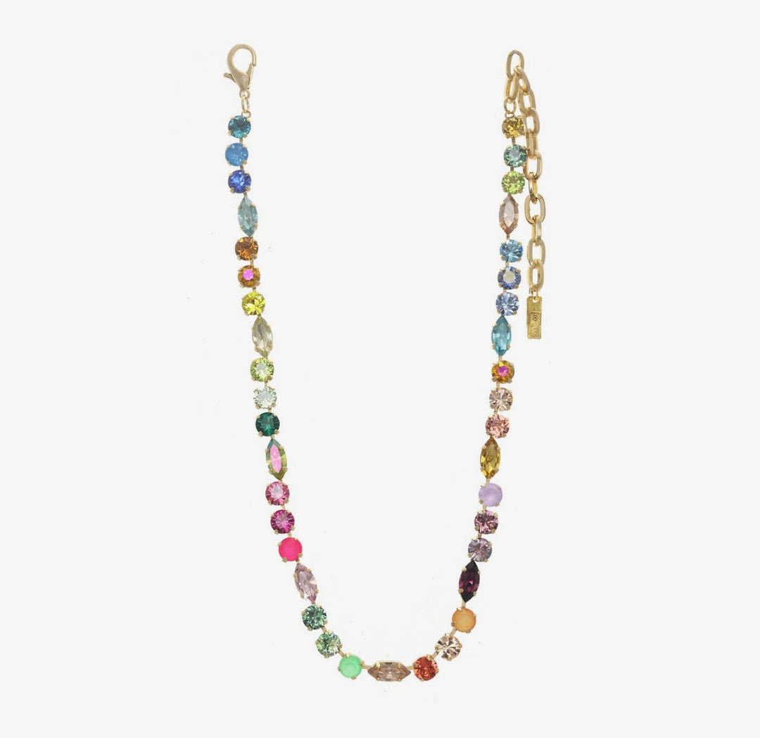A gold-tone chain necklace featuring a strand of faceted, multi-colored beads in various shapes and colors, displayed on a light gray background.