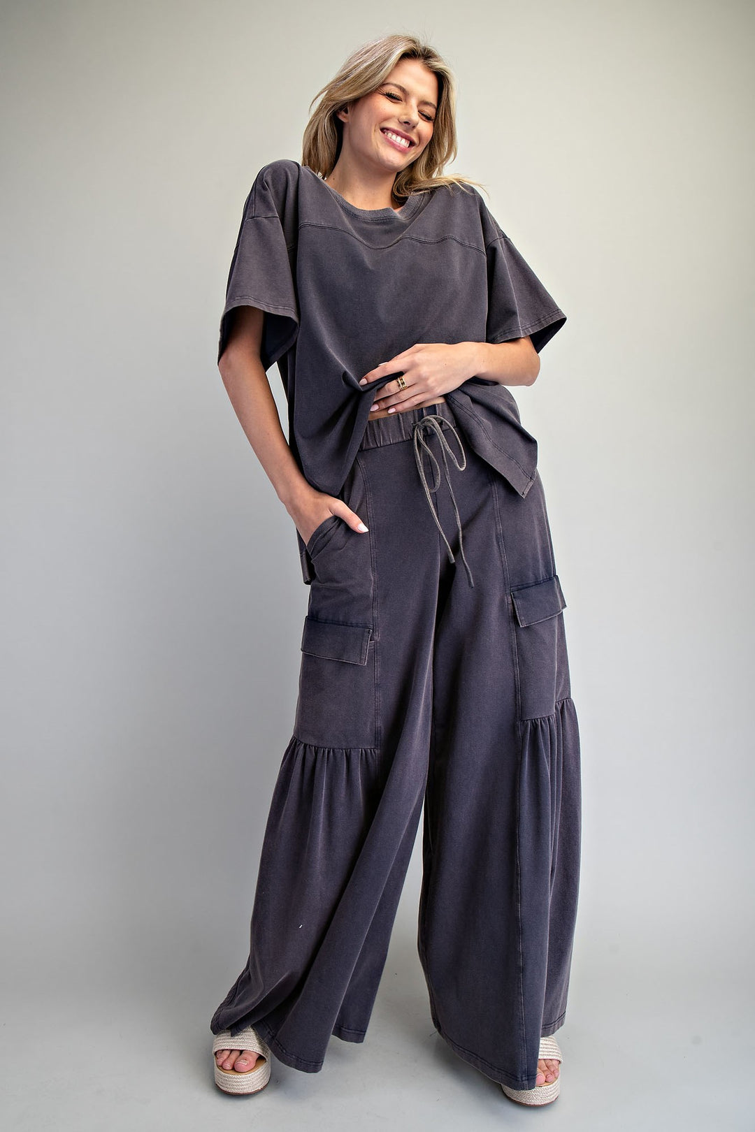 Woman wearing black wide leg pants and black shirt on plain background