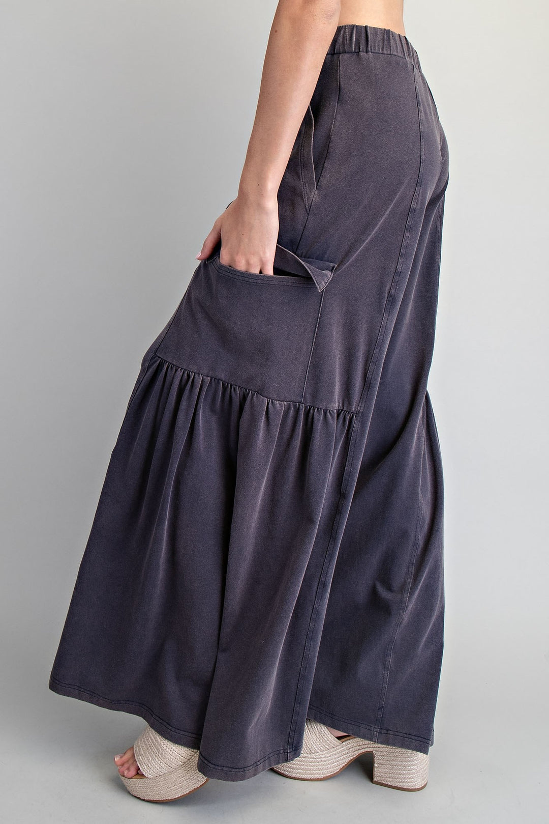 Navy blue wide-leg pants worn by a person on a gray background