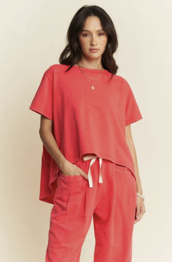 Woman wearing a coral outfit with a plain background