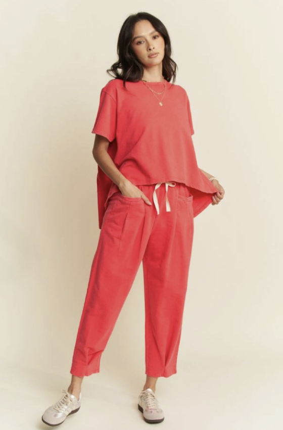 Woman wearing a coral outfit with a plain background