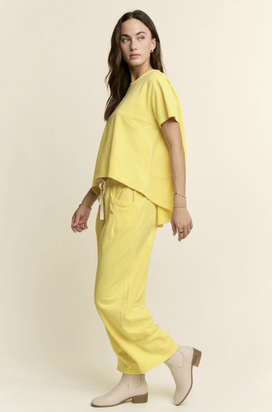 Woman wearing a yellow outfit on a plain background