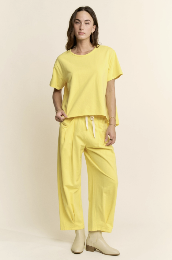 Person wearing a yellow outfit with a plain background