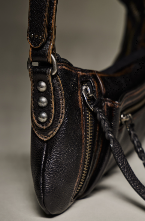 Close up of small black purse on beige background