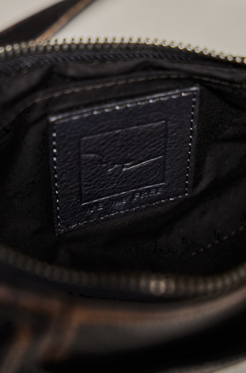 Close up of black purse on beige background