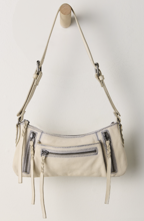 Small beige purse hanging on hook on white background