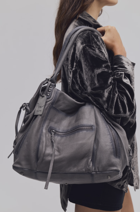 Woman wearing grey purse on shoulder on grey background