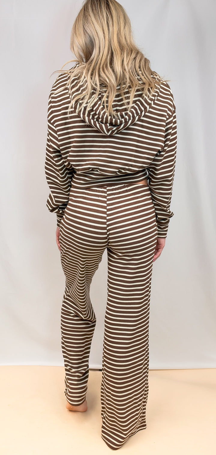 Woman shown from back wearing matching brown and white stripe set on plain background