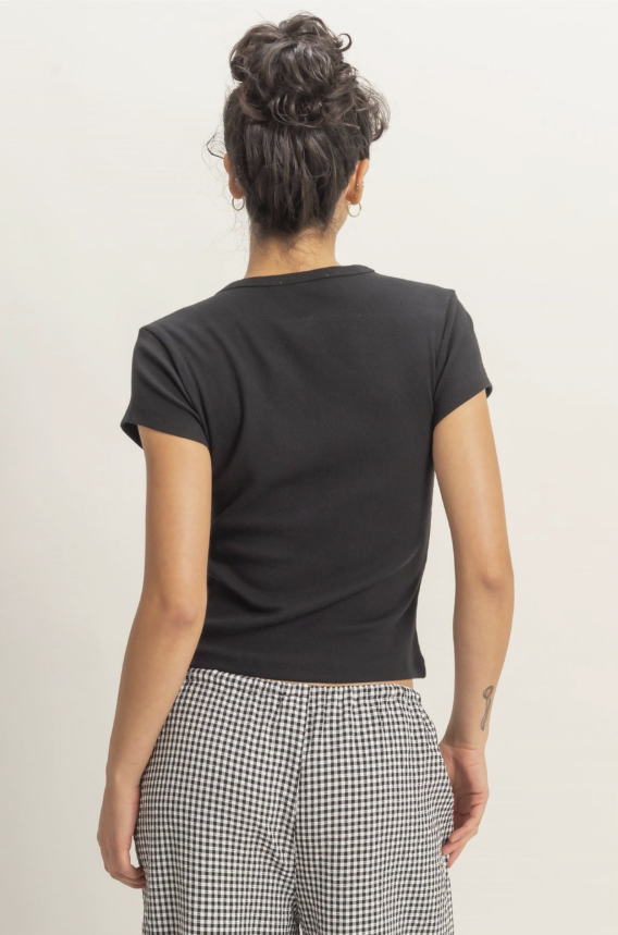 Person wearing a black t-shirt and checkered pants on a plain background