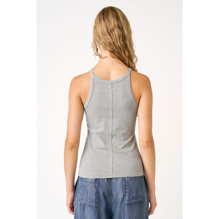 Woman wearing grey tank on plain background