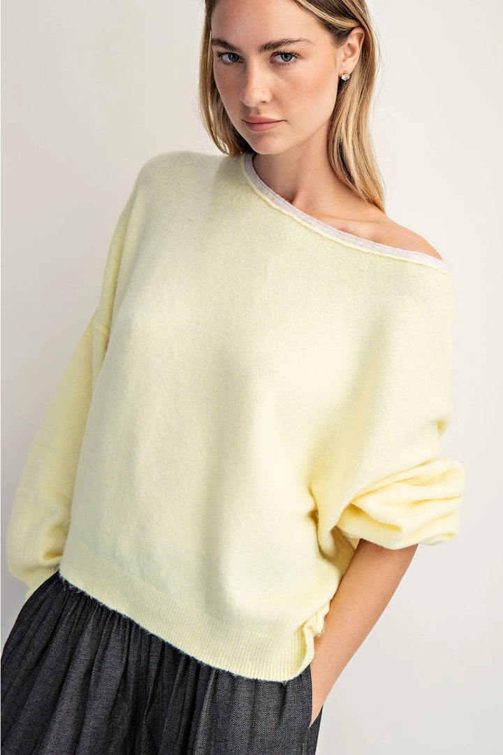 Woman wearing a light yellow poncho against a plain background