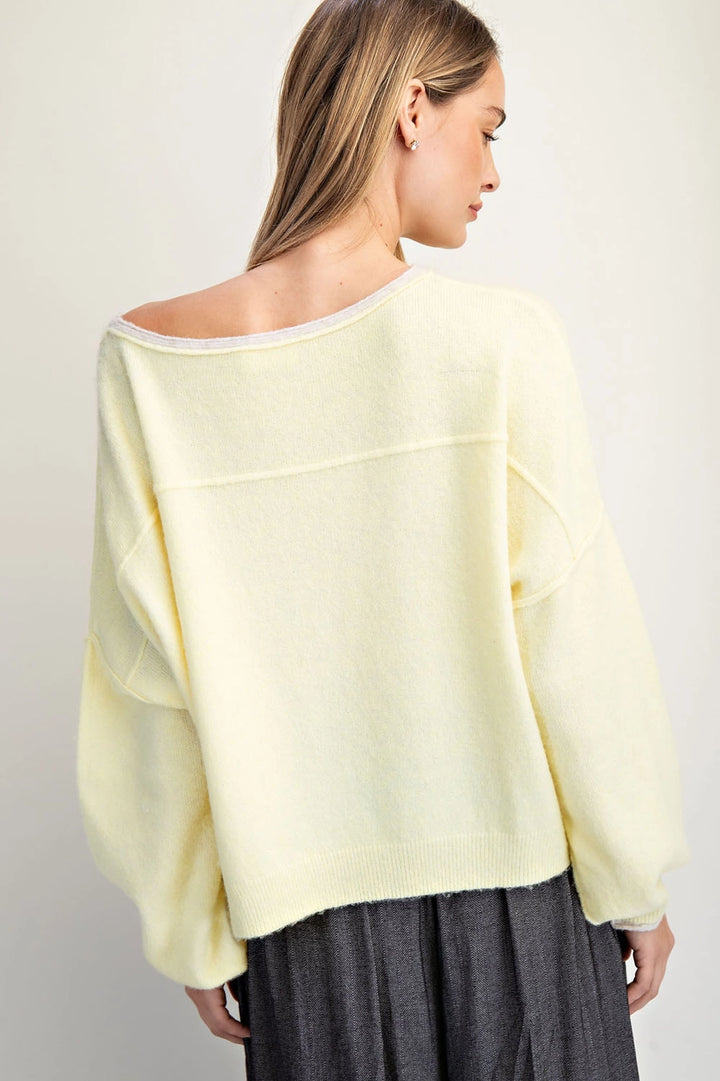 Woman wearing a light yellow blouse with a plain background