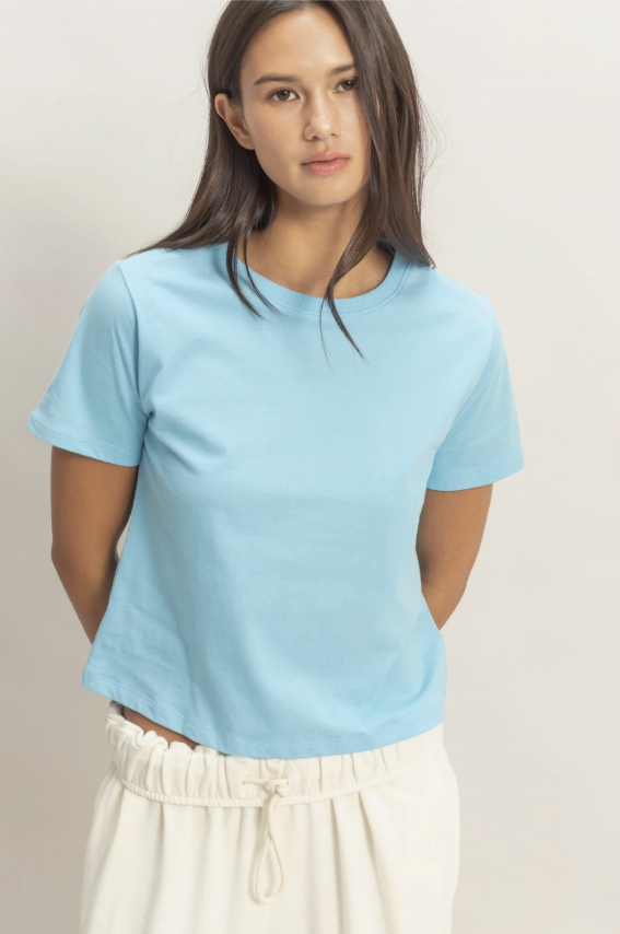 Woman wearing a light blue t-shirt against a plain background