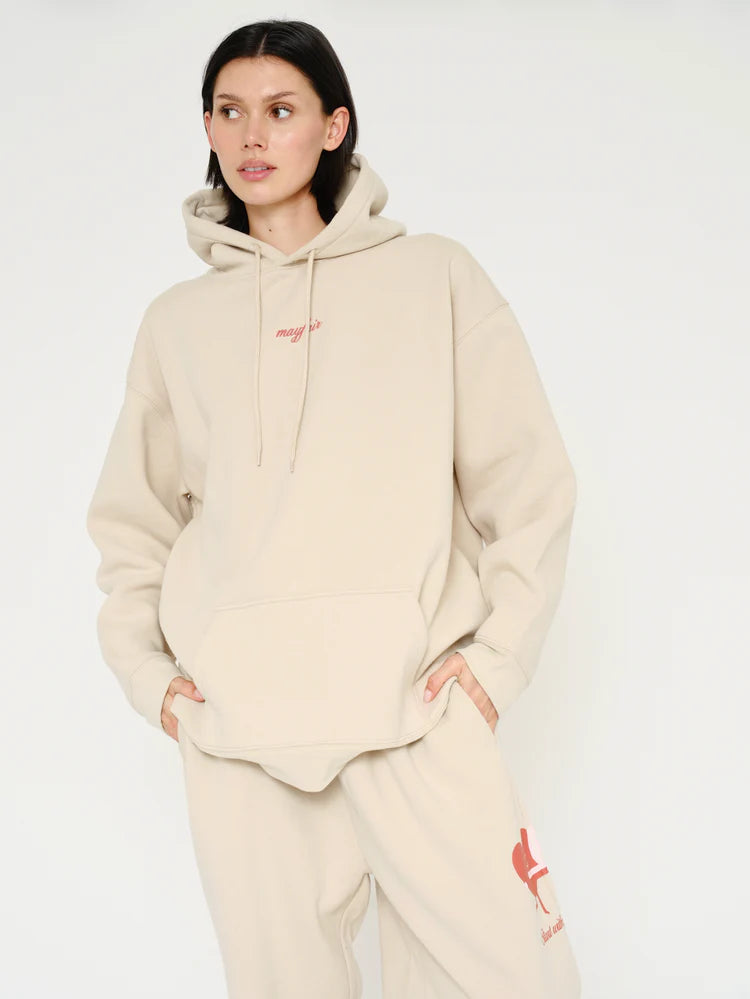 Woman wearing a beige hoodie and pants with a brand logo on a white background
