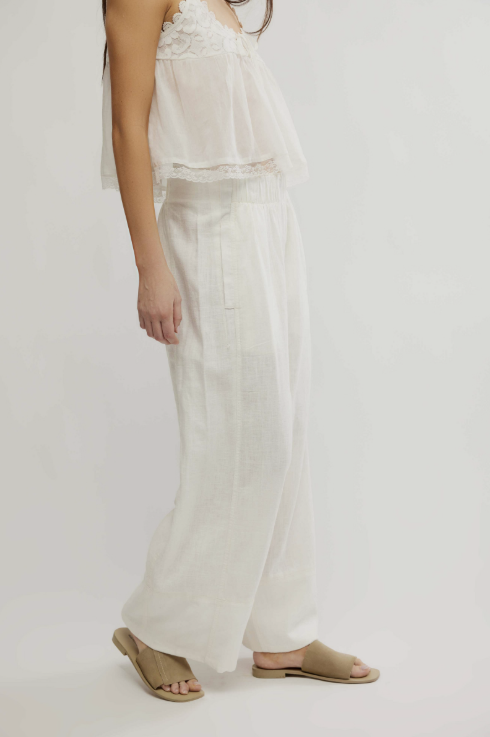 Person wearing a white outfit with a plain background