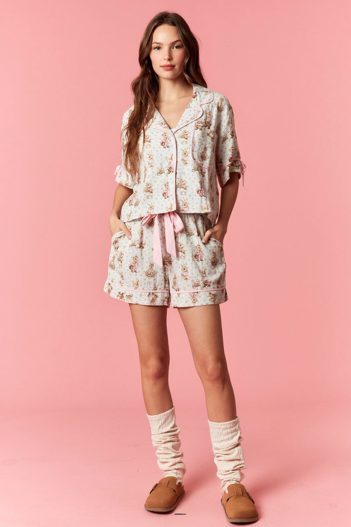 Woman wearing a floral pajama set on a pink background