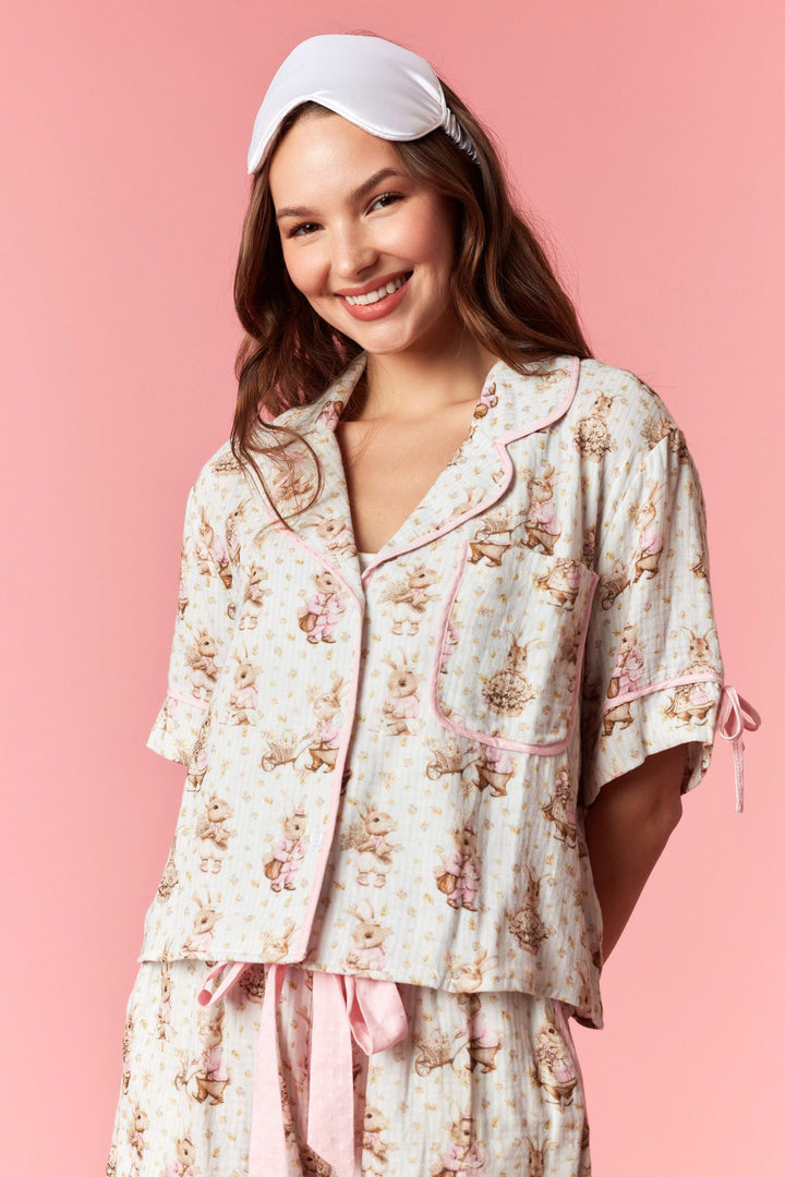 Woman wearing a floral pajama set with a pink background