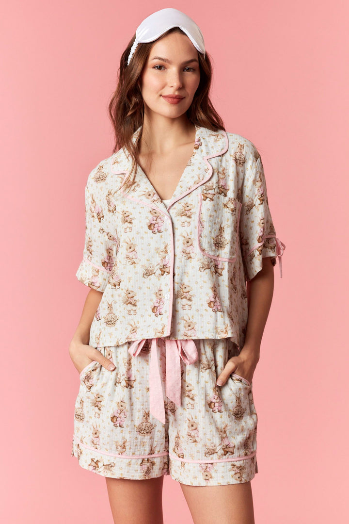Woman wearing a floral pajama set with a pink background