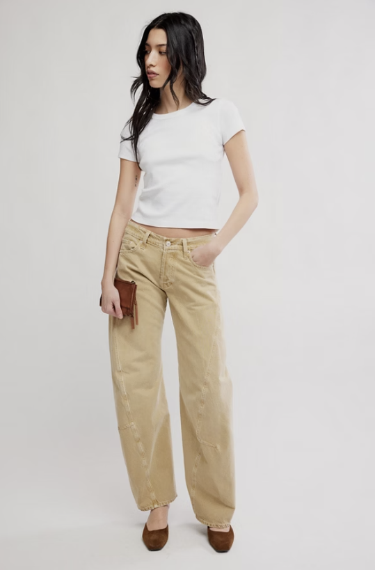 Woman wearing white tee and beige jeans on white background