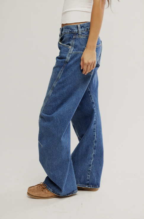 Person wearing blue jeans on a plain background