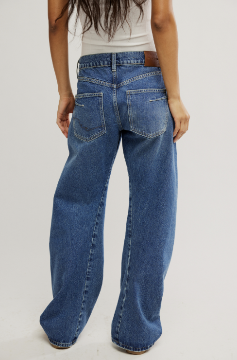 Person wearing blue jeans on a plain background