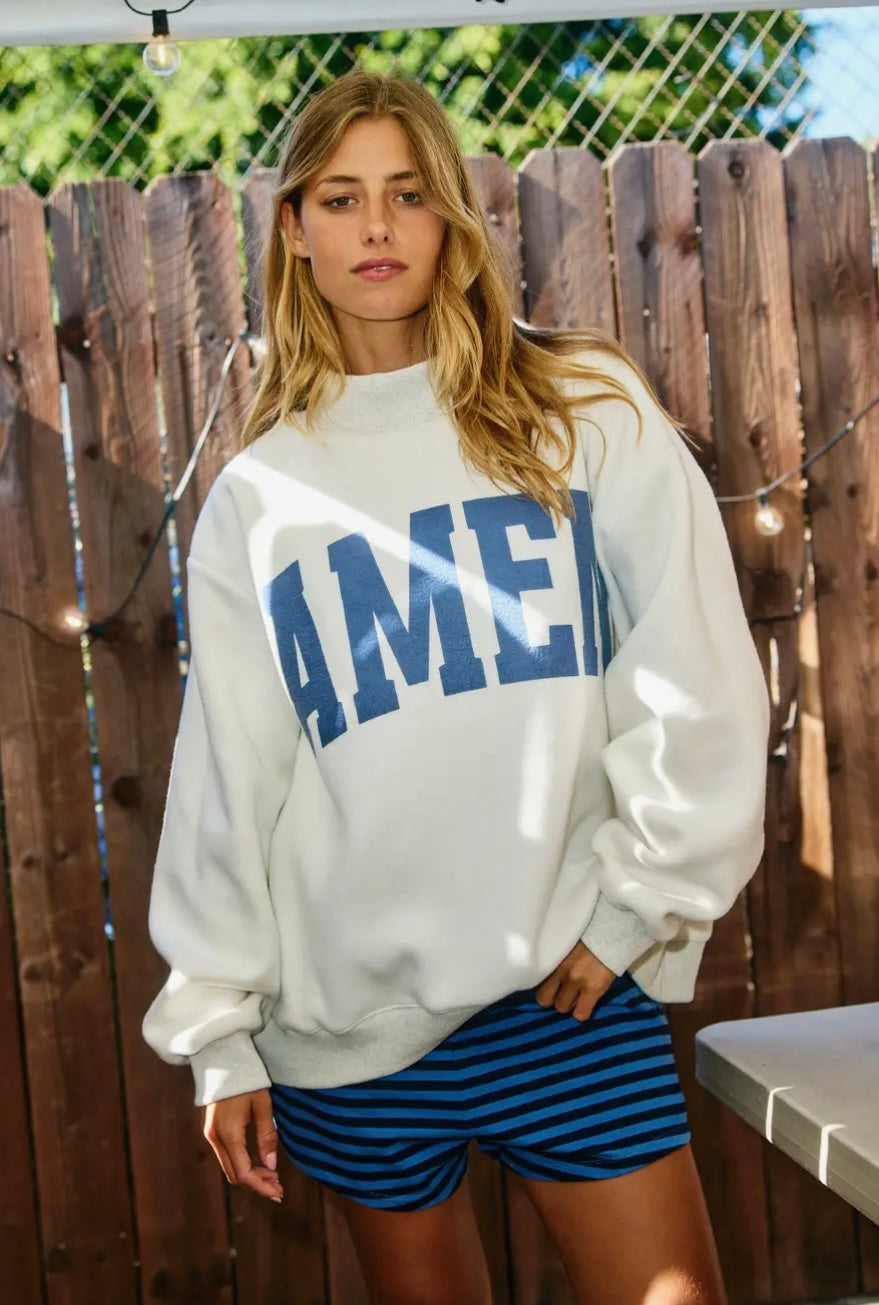 Person wearing a white sweatshirt with &