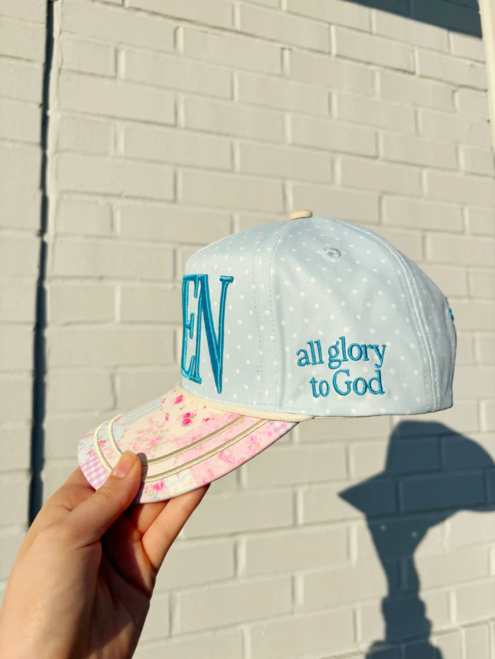Hand holding hat embroidered with &