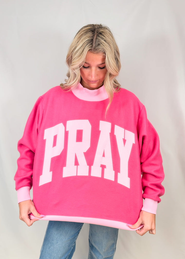 Woman wearing pink mock neck sweatshirt with &