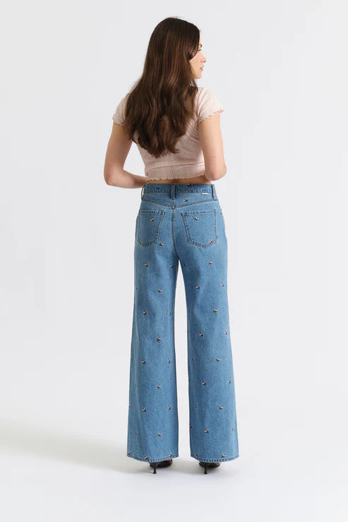 Woman wearing blue jeans with decorative studs on a white background