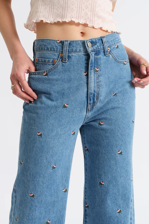 Blue jeans with decorative studs on a white background