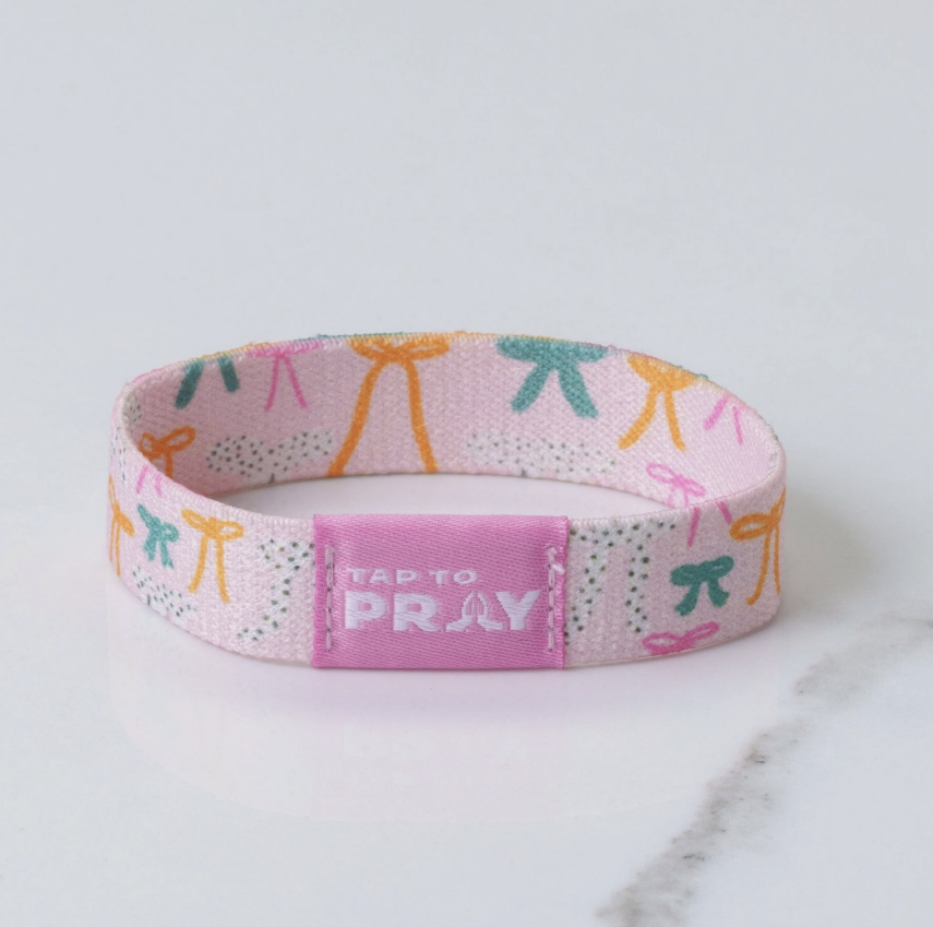 Pink wristband with colorful designs and &
