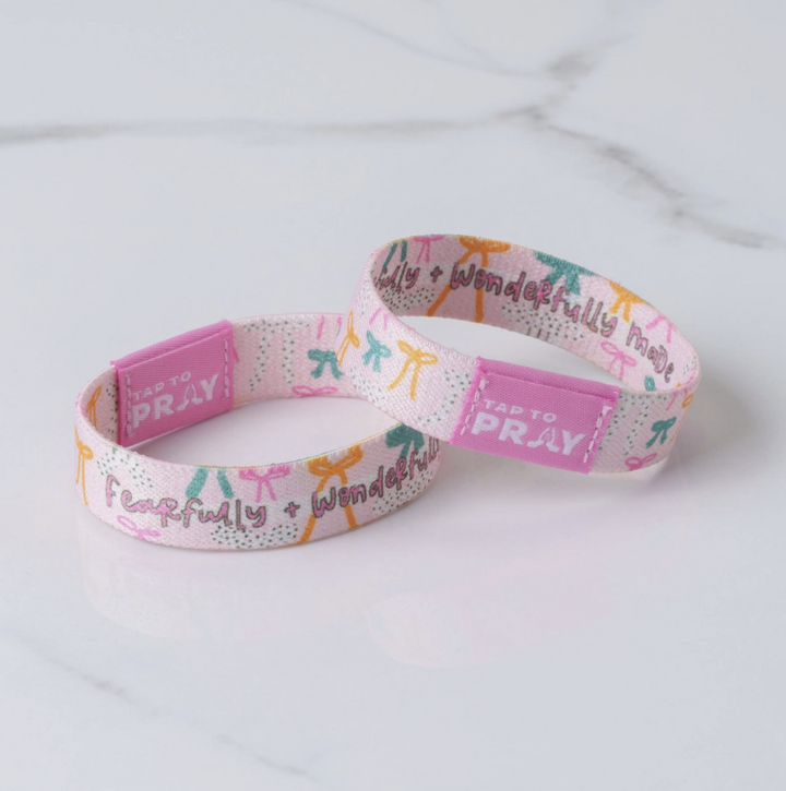 Two colorful wristbands with text on a light gray background