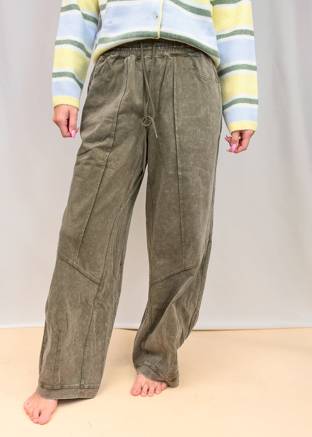 Woman wearing green pants on plain background