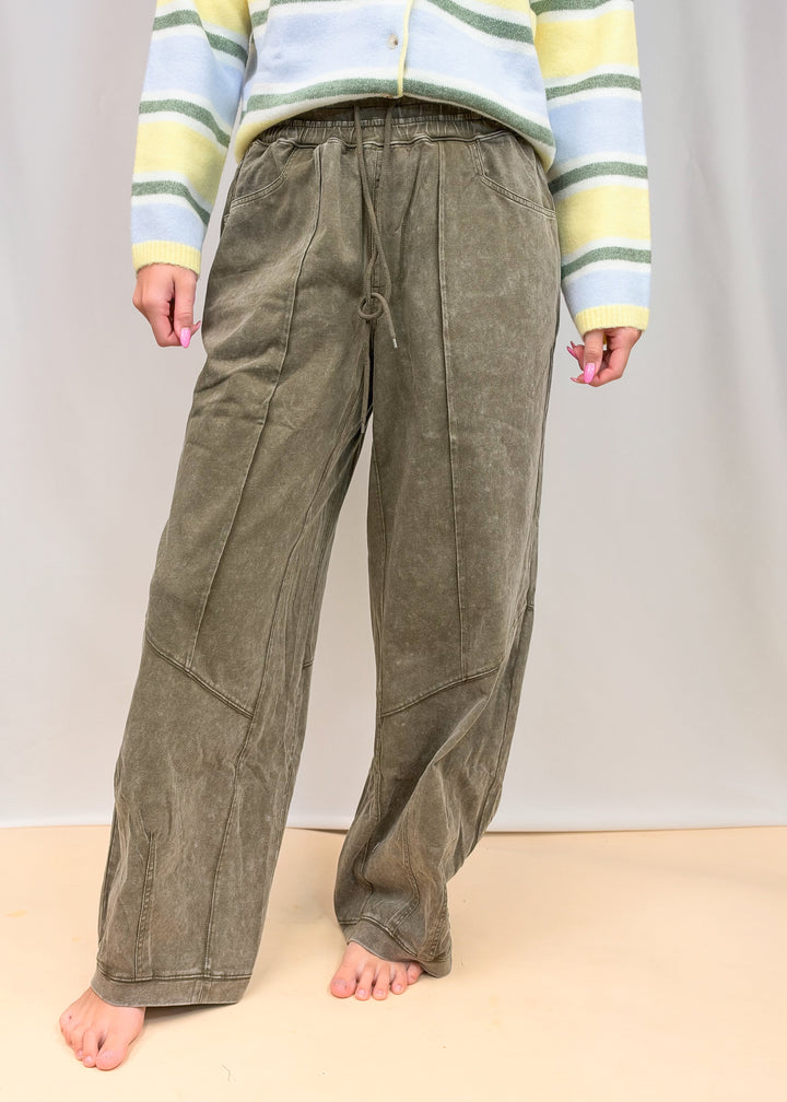 Woman wearing green pants on plain background