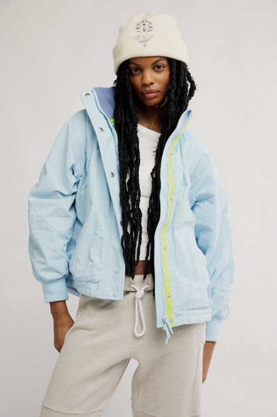 Woman wearing light blue jacket on white background