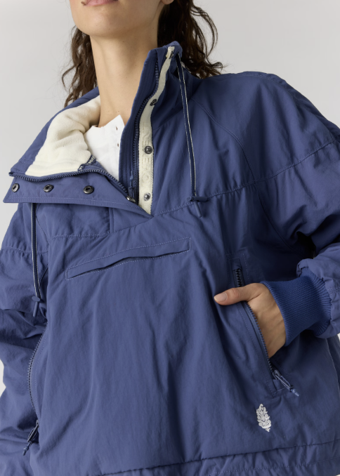 Close up of woman wearing navy pullover jacket on plain background