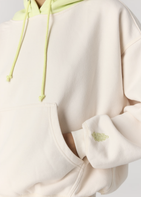 Close up of woman wearing beige hoodie with yellow accents