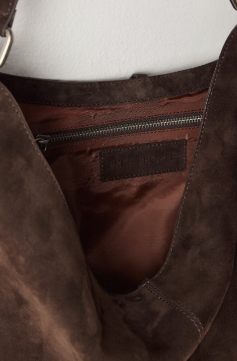 Close-up of a brown leather bag with a visible brand label.