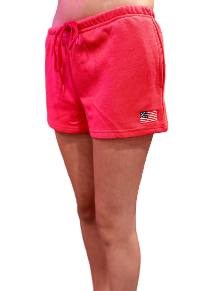 Red shorts with a small flag patch on a blurred background
