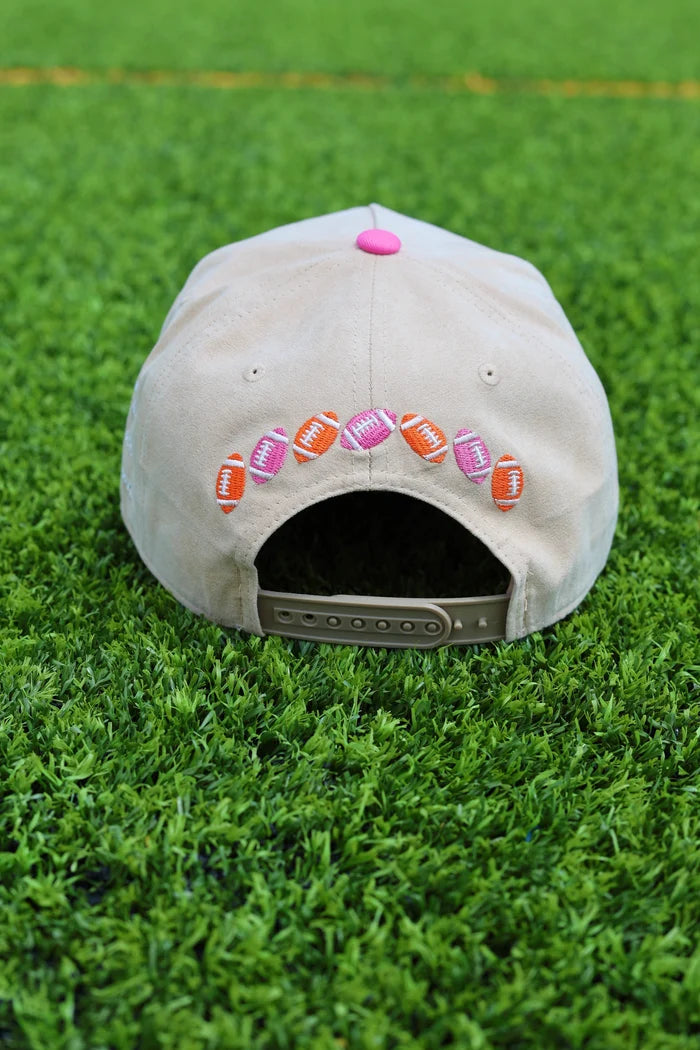 trucker hat with footballs embroidered across back on grass
