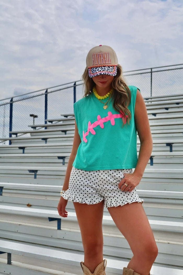 Woman wearing neon football shirt and trucker hat with &