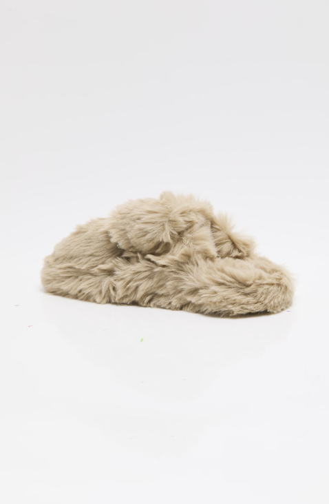 A single fluffy faux-fur slide sandal in a light beige or oatmeal color, photographed on a seamless white studio background.