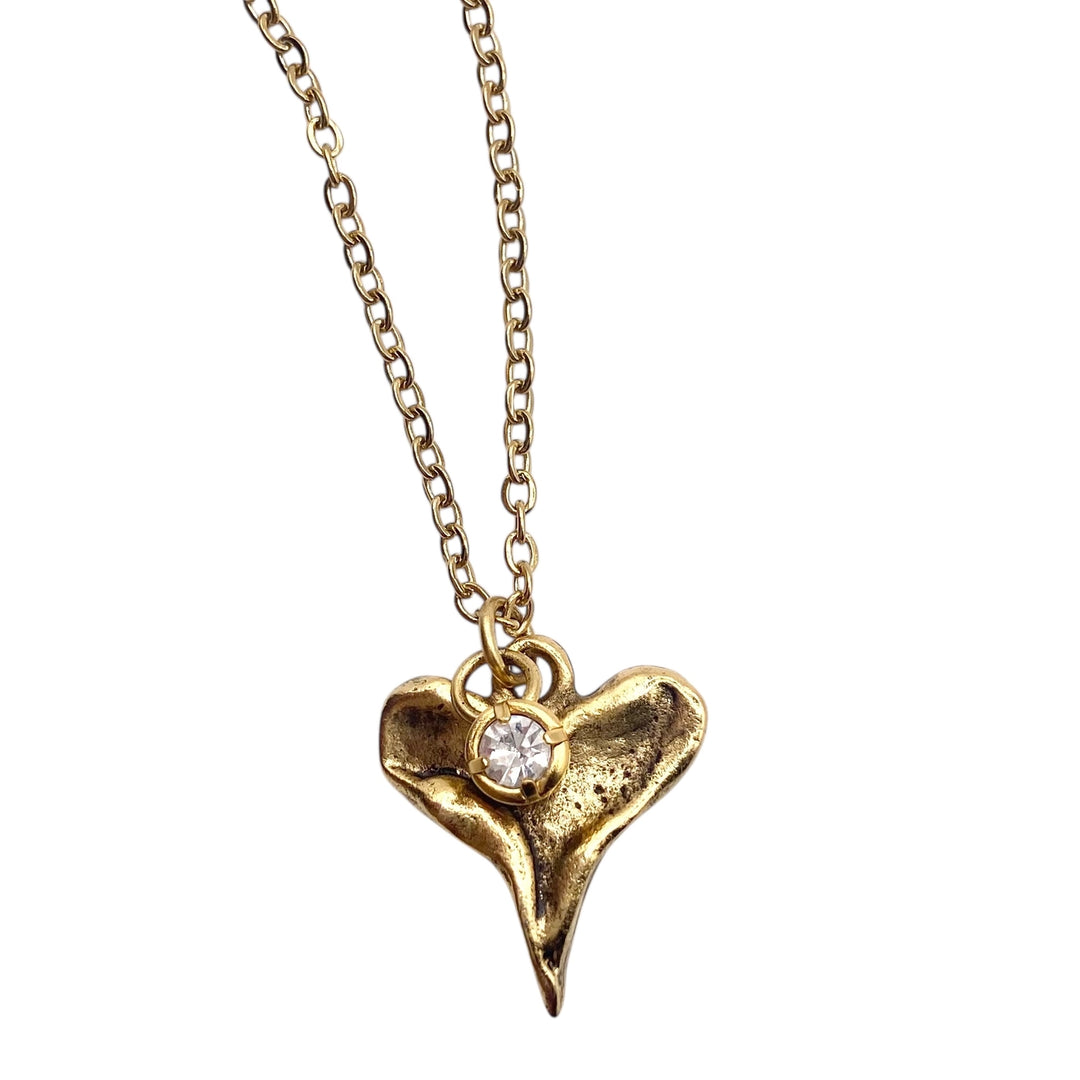 Gold necklace with a heart-shaped pendant on a white background