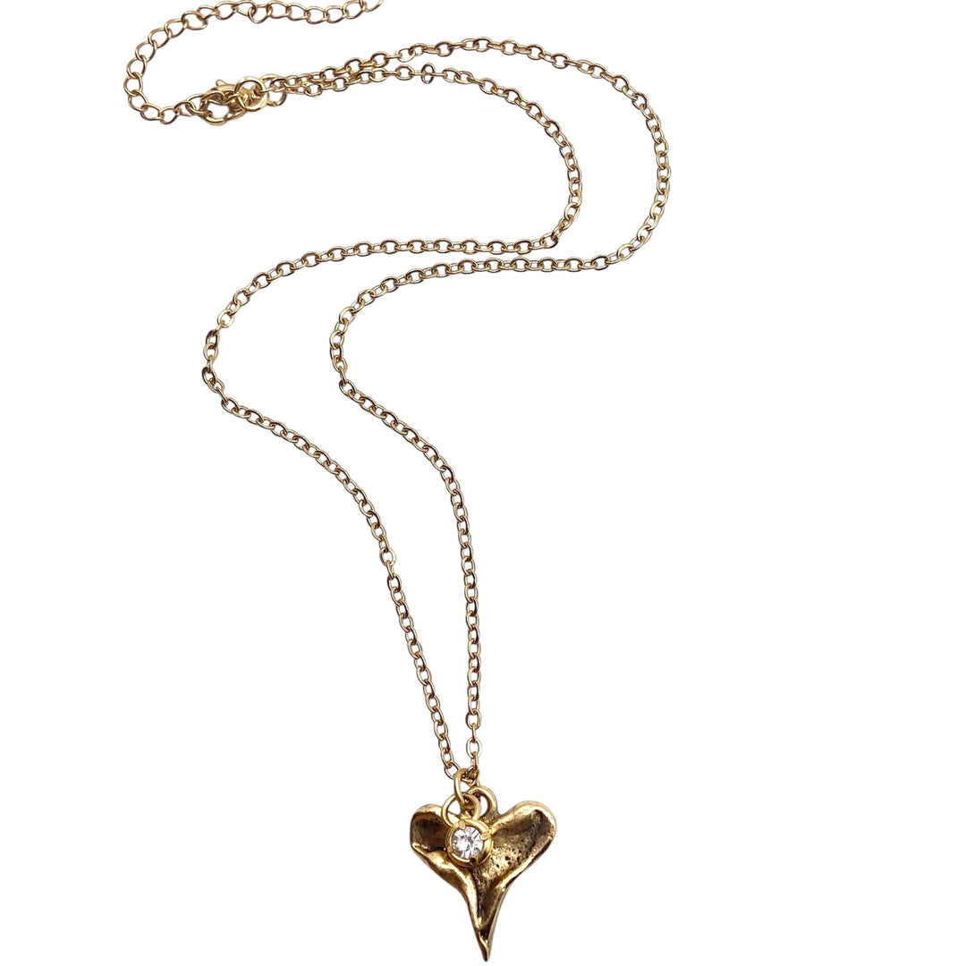 Gold necklace with a heart-shaped pendant on a white background