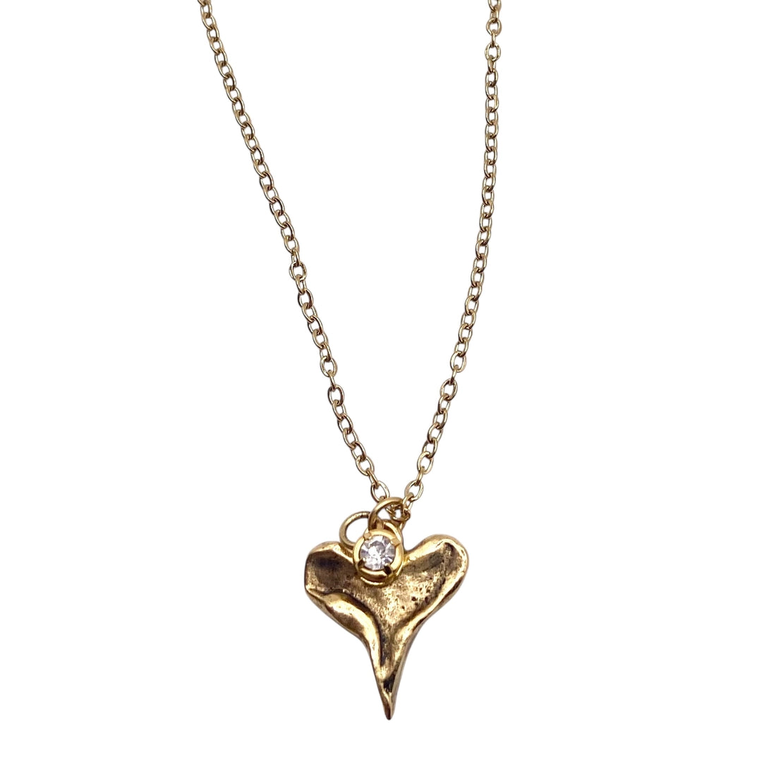 Gold necklace with a heart-shaped pendant on a white background