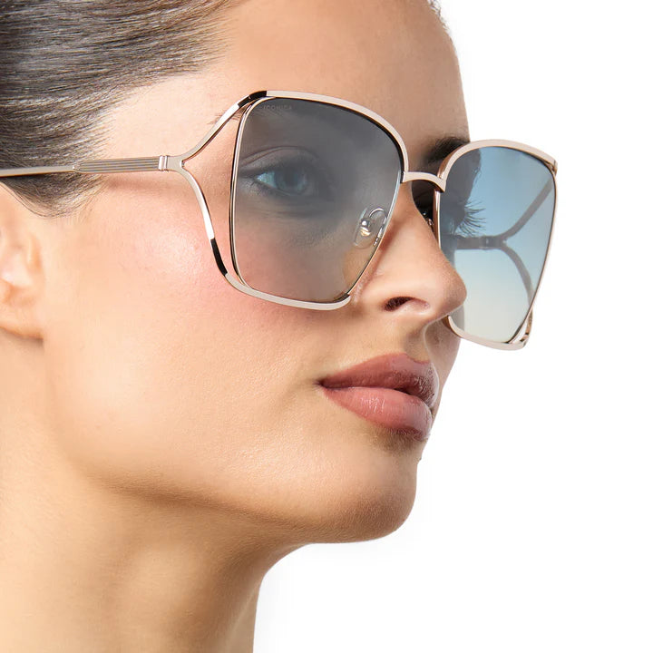 Close-up of a person wearing large sunglasses with a neutral background