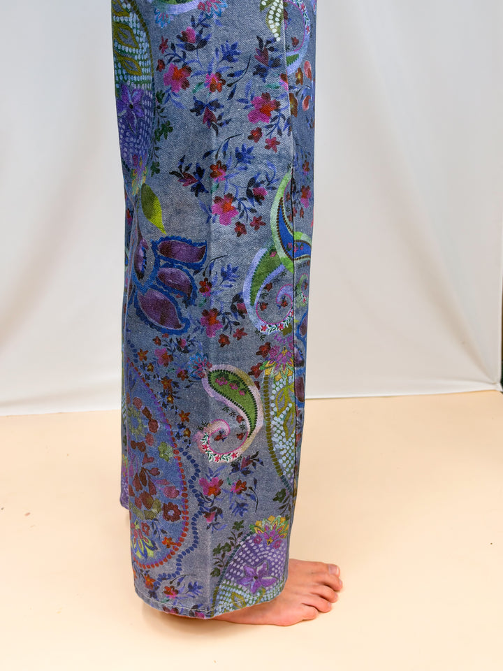 Close up of blue paisley jeans on plain background