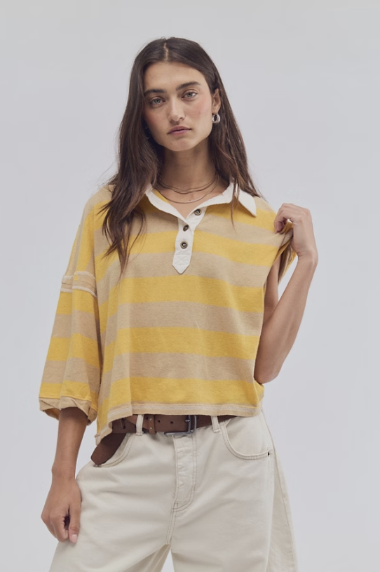 Woman wearing a yellow and beige striped shirt with a plain background