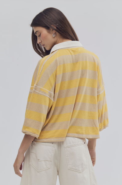 Back of woman wearing yellow and beige stripe shirt on white background
