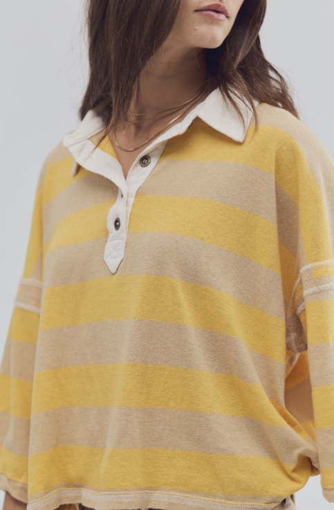 Person wearing a yellow and beige striped shirt against a white background